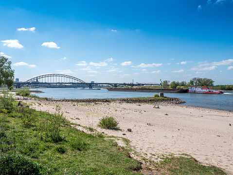 Sandy beaches along the river Waal near Nijmegen, The Netherlands with the Waalbridge in the background
