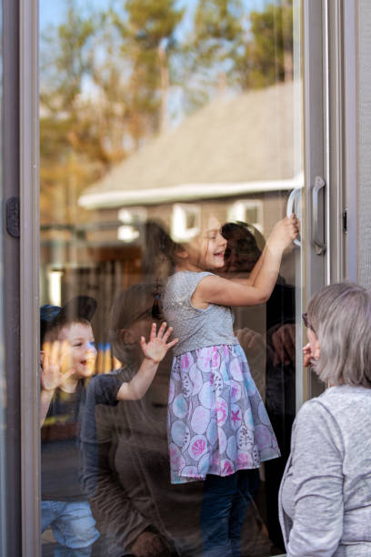 istock Grandparents visiting grandkids during quarantine through window 1222959817