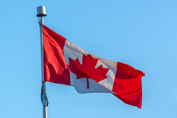 istock Canadian flag on a pole, blue sky background 1222959818