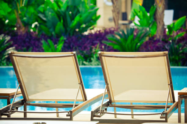 istock two empty sunbeds near swimming pool 1222963331