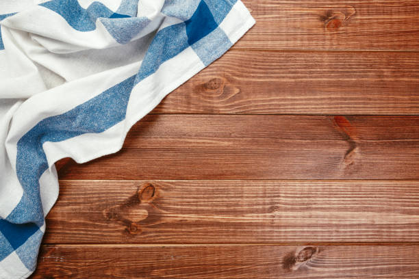 istock Top view on a dark wooden table with a linen kitchen towel or textile napkin. a tablecloth on a countertop made of old wood. Copy space for text. 1222965541