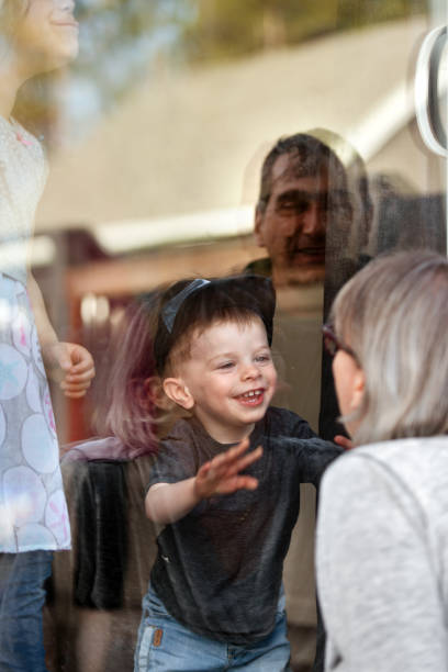 istock Grandparents visiting grandkids during quarantine through window 1222965655