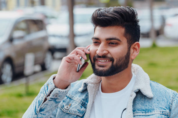 istock Bearded Indian man on the street using the application in his smartphone. 1222965832