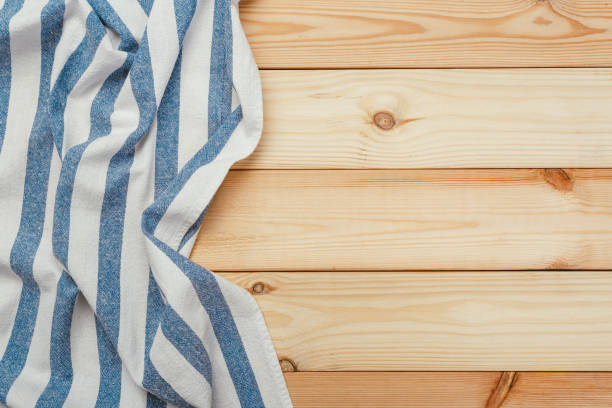 istock Top view on a wooden table with a linen kitchen towel or textile napkin. a tablecloth on a countertop made of old wood. 1222965861