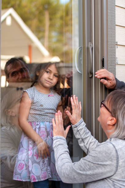 istock Grandparents visiting grandkids during quarantine through window 1222968984