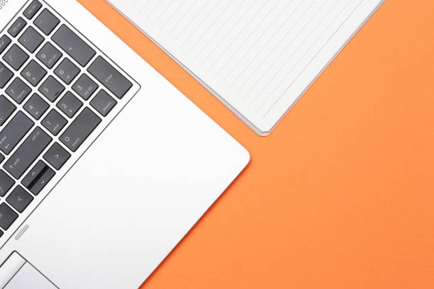istock Notebook and laptop on an orange background, top view, copy space, concept online courses 1222970082