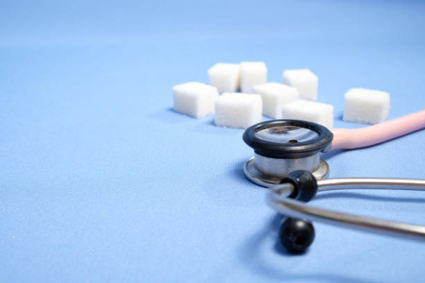 istock Pink stethoscope, sugar cubes on a blue background, diabetes. Space for text, selective focus 1222970976