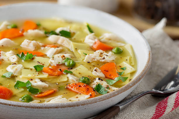 Bowl of Chicken Noodle Soup Closeup of a bowl of chicken noodle and vegetable soup chicken soup stock pictures, royalty-free photos & images