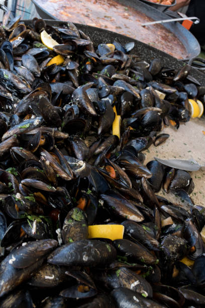 istock Fresh mussels in shells at steam pan. Seafood barbecue outdoors. 1222972796