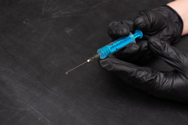 istock Hands in black protective gloves with a syringe. Medicine, 1222973933
