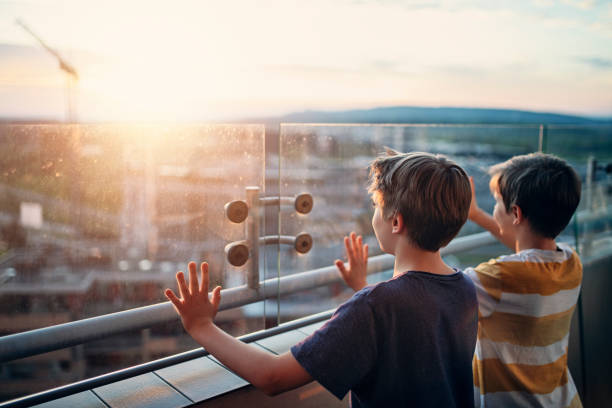 dvě děti na balkoně při pohledu na západ slunce - 10 až 11 let dítě před pubertou fotky - stock snímky, obrázky a fotky