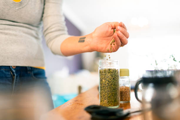 istock Woman pours beans into jar from hand 1222977566