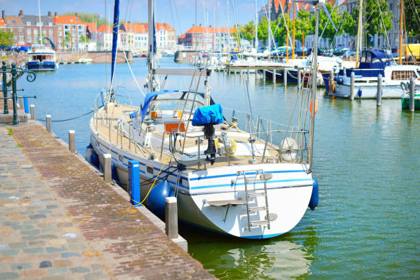 화창한 봄날 운하의 부두에 정박한 범선. 요트와 역사적인 건물을 배경으로 합니다. 미델부르크, 네덜란드 - yacht harbor anchored bay 뉴스 사진 이미지