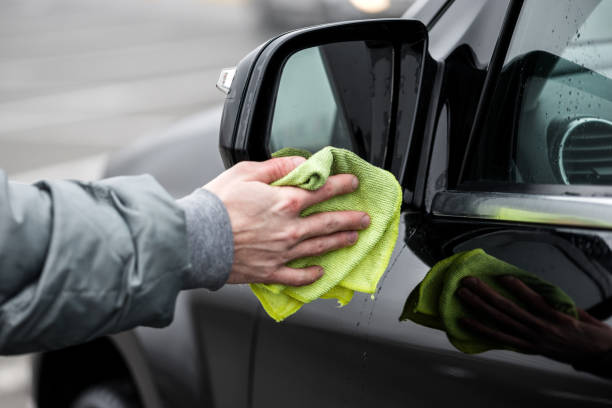 istock A man cleaning left car's mirror with microfiber cloth, car detailing  concept. 1222980605