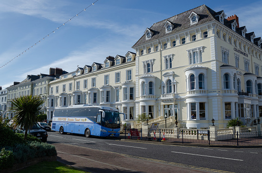 Llandudno, UK : May 6, 2019: A tourist coach operated by Gee-Vee Executive Travel of Barnsley, parked outside a hotel on the promenade.