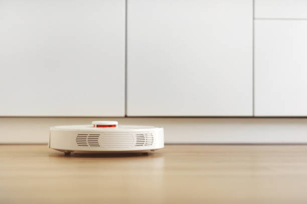 istock white robotic vacuum cleaner. The robot is controlled by voice commands for direct cleaning. Modern technology of smart cleaning. scheduled cleaning of the apartment. selective focus 1222983230
