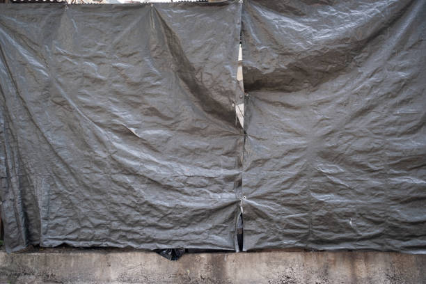 Crumpled canvas cover at construction site, Grey colour, Security concept