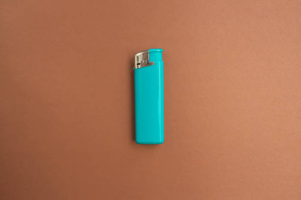 istock blue lighter with a button on a brown and white background. Top view. Mock up. Flat lay composition 1222986534