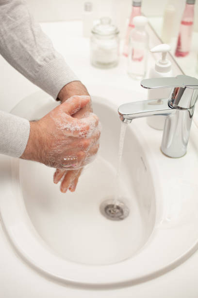 istock man washing hands with soap at home. coronavirus prevention hand hygiene 1222988792