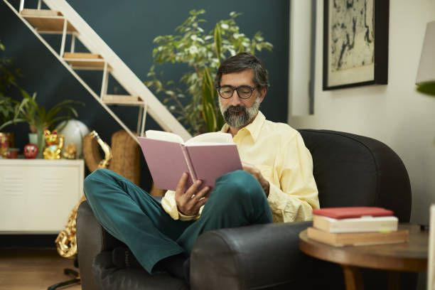 istock One mid adult man reading a hard cover book. 1222995719