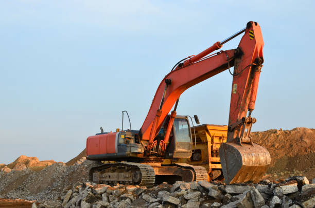 istock Excavator in a working at granite quarry unloads old concrete stones for crushing and recycling 1222996618