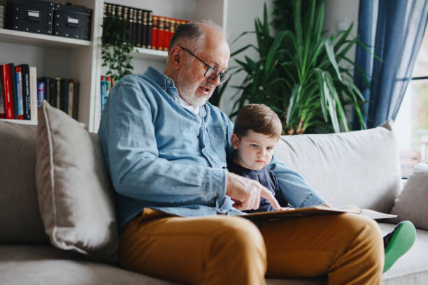 istock Grandfather reading book with his grandson 1222997351