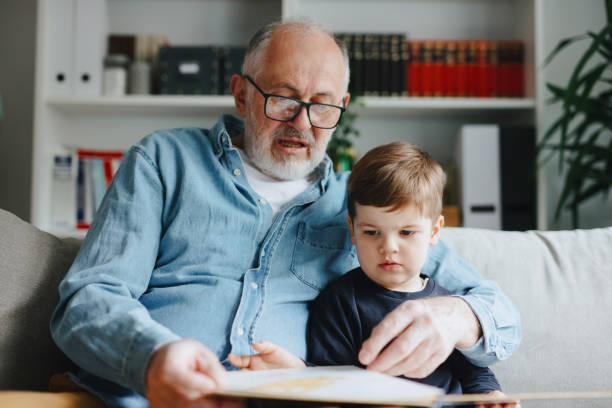 istock Grandfather reading book with his grandson 1222997383