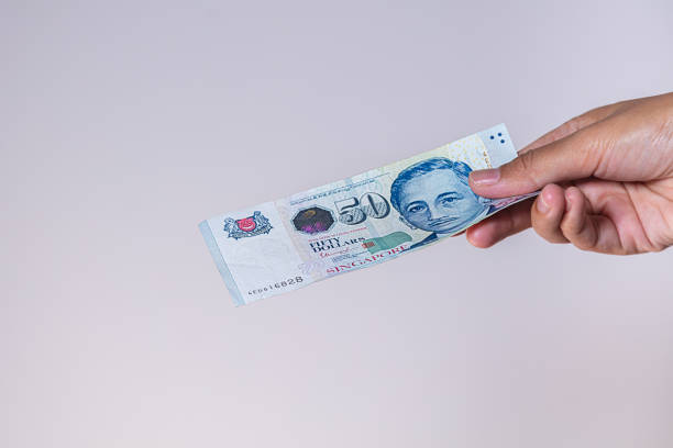 istock Singapore dollars in female hands 1222998272