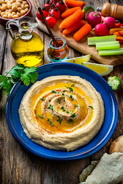 istock Vegan food: hummus in a plate with pita bread and vegetables. top view 1223001482