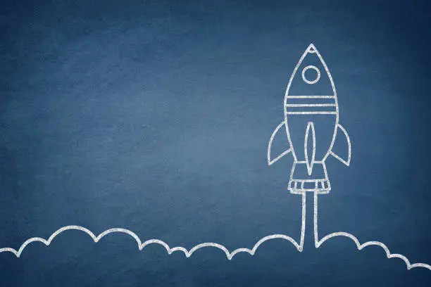 Business startup concept with space shuttle drawing on blue chalkboard