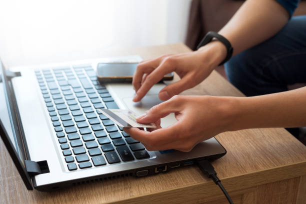 istock Woman holding credit card and using laptop computer for online shopping.  E-commerce or internet banking concept. Selective focus 1223004098