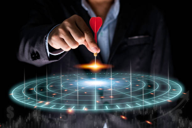 Businessman throwing red arrow dart to virtual target dart board. Setup objectives and target for business investment concept.
