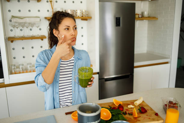 istock Young woman preparing a green smoothie at home 1223005473