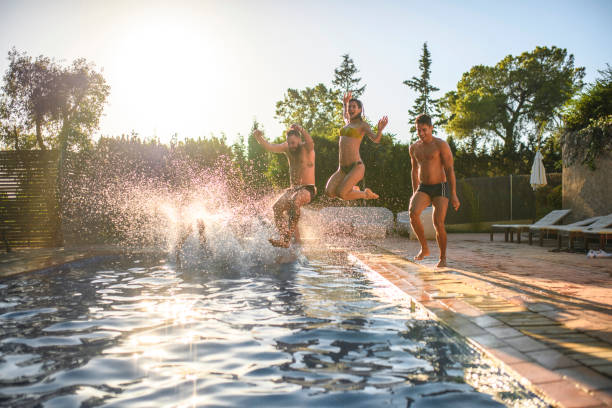 istock Friends Running and Jumping into Swimming Pool 1223006661