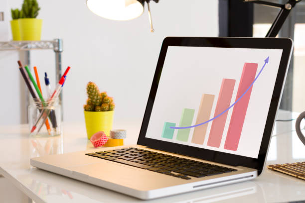 istock Computer on the desk with Business charts upward. Pastel palette 1223007946
