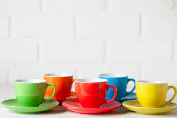 istock Colorful cups on the white background of a brick wall. Background with copy space. Horizontal. Selective focus. 1223008038