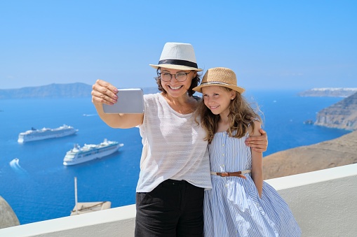 Mother and little daughter traveling together in Mediterranean, Greece, Santorini island