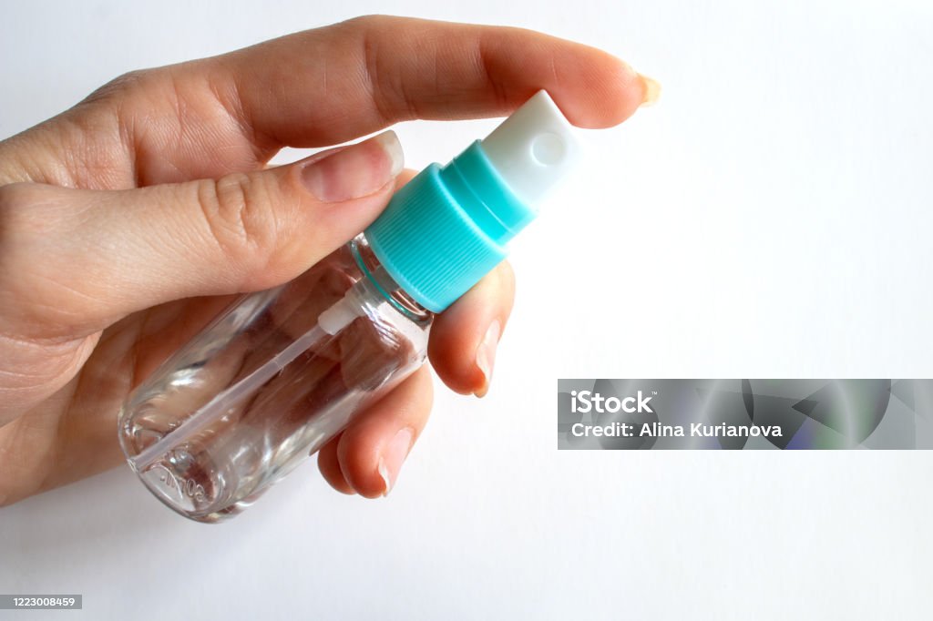 Transparent spray bottle in hand. Health concept. Antiseptic. Coronavirus control measures. Aerosol Can Stock Photo
