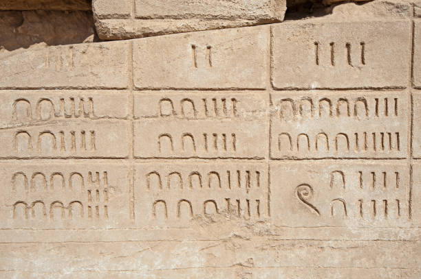 Hieroglyphic numerical carvings on an ancient egyptian temple wall stock photo
