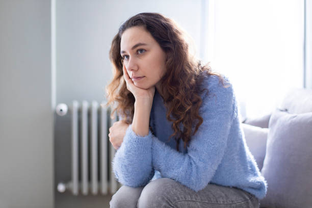 istock Depressed young woman on sofa at home 1223010356