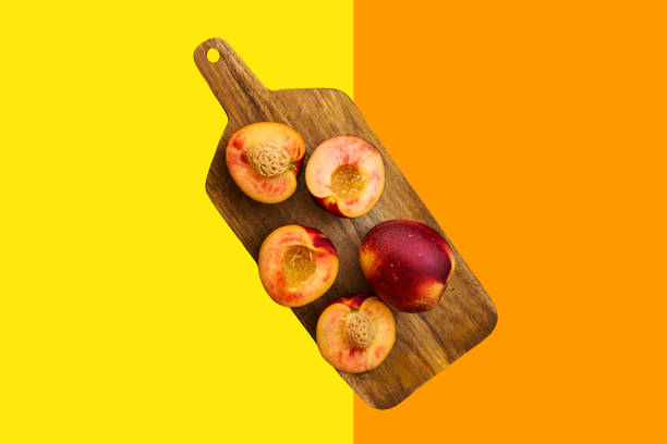 Bunch of whole cut in half juicy raw fresh nectarines on wooden board on duotone yellow orange background. Summer fruits Bunch of whole cut in half juicy raw fresh nectarines on wooden board on duotone yellow orange background. Summer fruits healthy plant based diet superfoods concept entire track stock pictures, royalty-free photos & images