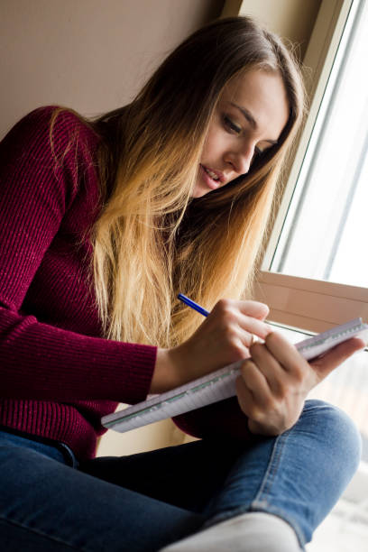 istock woman writing in a note book at home 1223012912