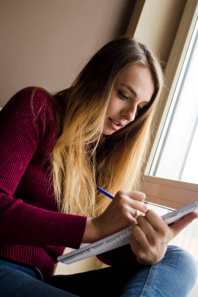 istock woman writing in a note book at home 1223012925