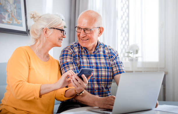 집에서 노트북을 사용하여 청구서를 확인하는 노인 부부 - home finances calculator finance senior couple 뉴스 사진 이미지