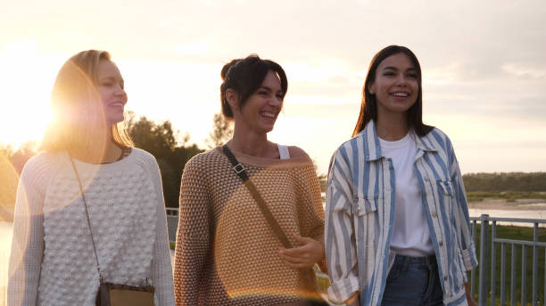 istock Three female friends walking down waterfront smiling and talking 1223014446