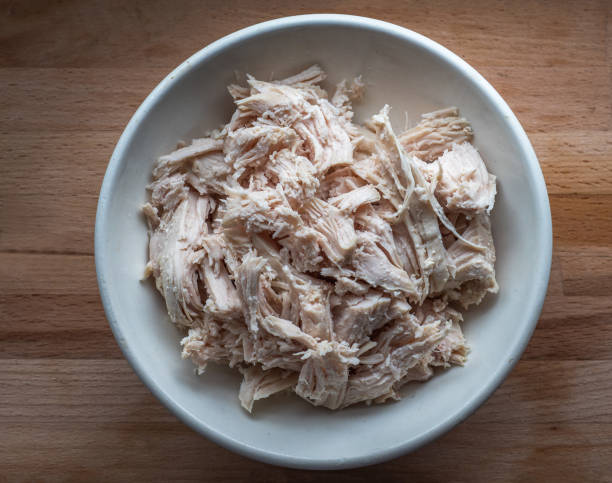 istock Shredded chicken meat for salads in a deep plate stands on the kitchen board 1223014567
