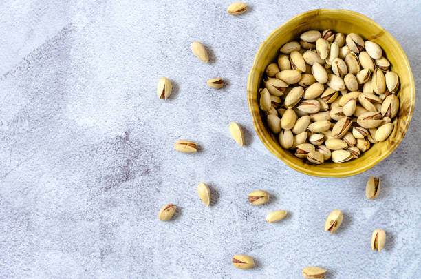 istock Pistachios in a brown bowl. Pistachios on a light background. Top view, flat lay. 1223015445
