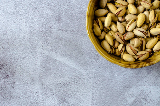 istock Brown bowl with shell pistachios on a gray background. Healthy eating concept. 1223015903