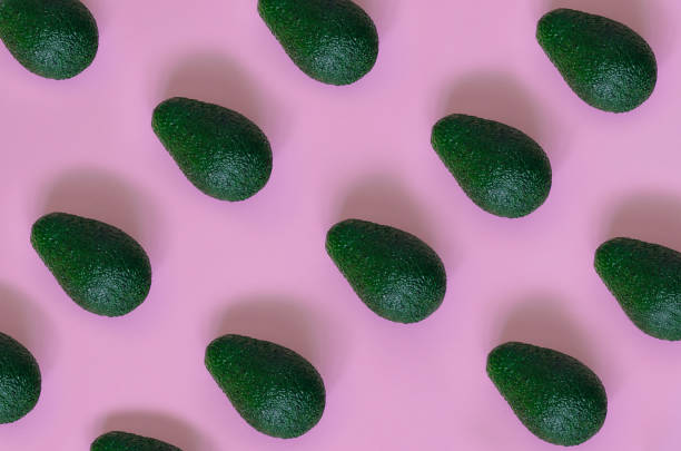 istock Avocado on a pink background. Avocado texture top view. Banner. Pop art design, creative concept of summer food. 1223015936