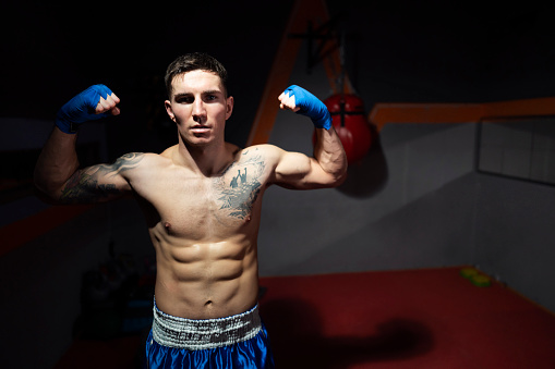 Portrait of a young male boxer who is ready for a match, fight, training.